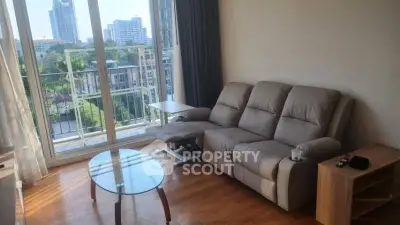 Spacious living room with cozy sofa and city view balcony in modern apartment.