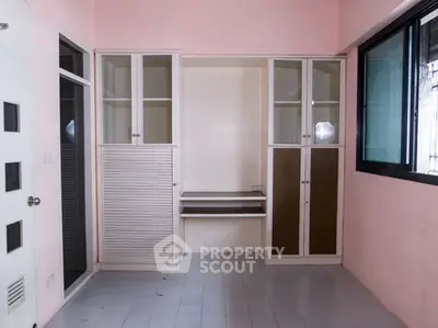 Spacious storage room with built-in cabinets and shelves in a modern apartment.