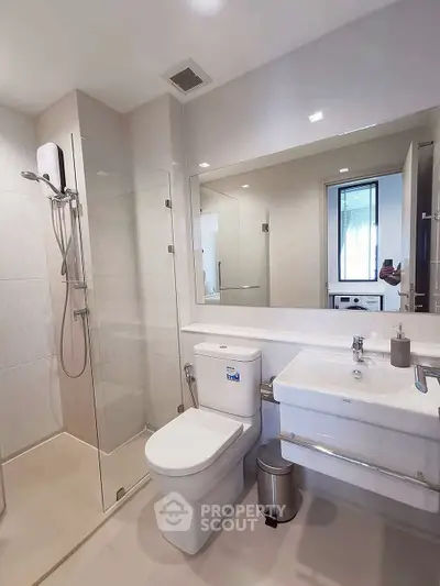 Modern bathroom with glass shower and sleek fixtures in a contemporary home.