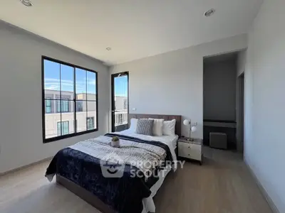 Spacious modern bedroom with large windows and stylish decor
