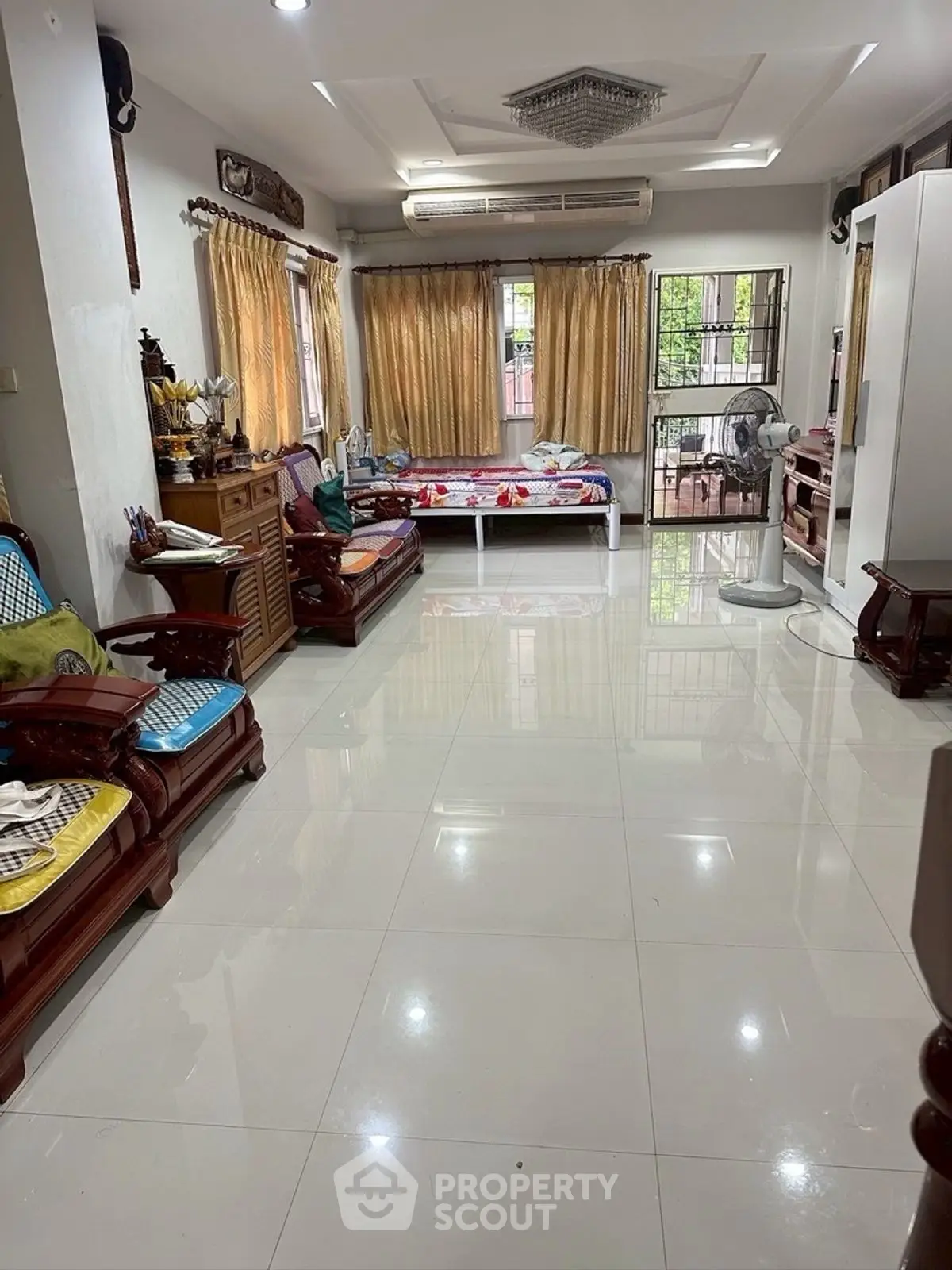 Spacious living room with elegant wooden furniture and large windows for natural light.