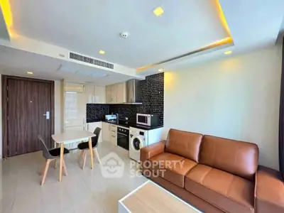 Modern living room with integrated kitchen, featuring sleek appliances and stylish furniture.