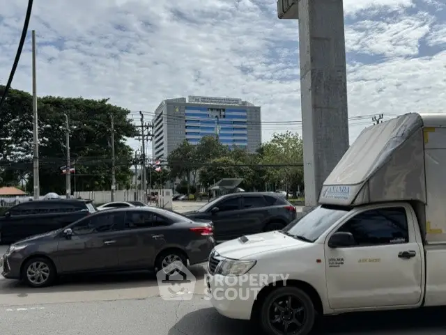 Urban street view with modern office building and traffic in foreground.