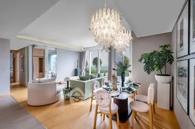 Luxurious open-plan living and dining area with elegant chandeliers and modern decor.