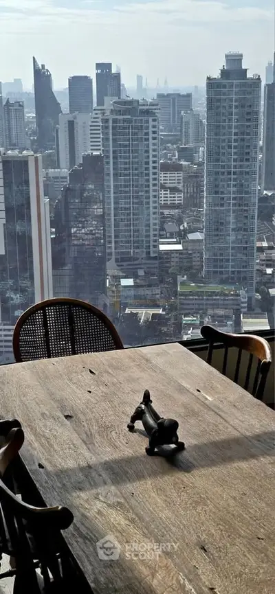 Stunning cityscape view from a high-rise apartment with a rustic wooden dining table.