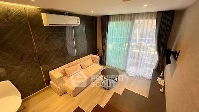 Modern living room with stylish sofa, air conditioning, and large window for natural light.