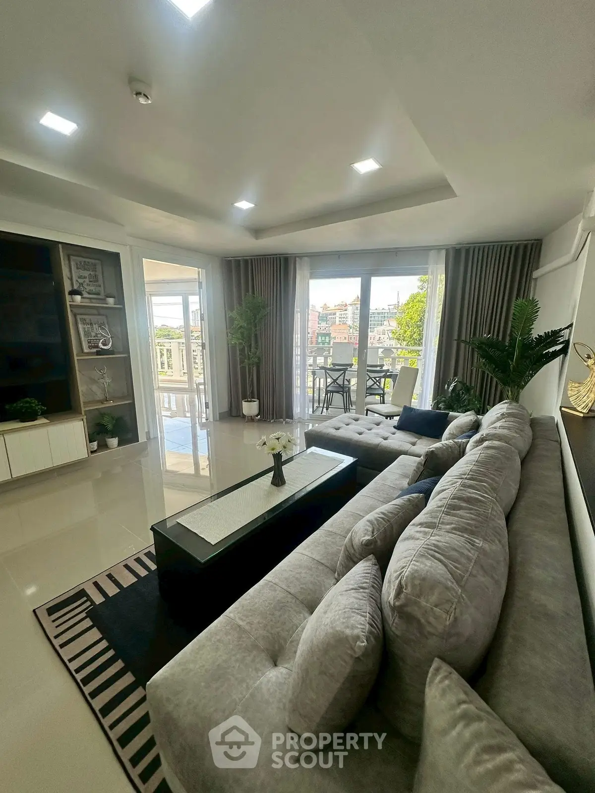 Luxurious living room with plush sofa and balcony view in modern apartment