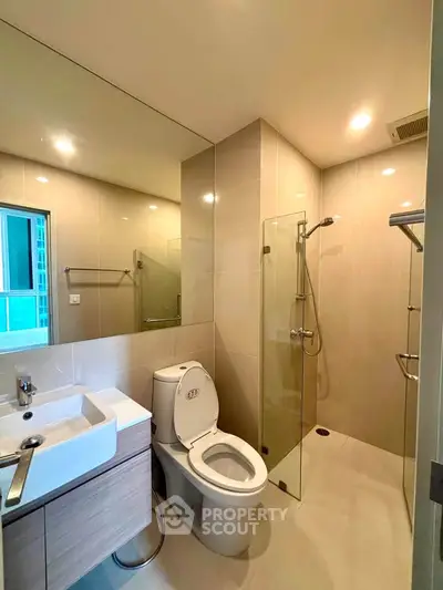 Modern bathroom with glass shower and sleek fixtures in a contemporary apartment.