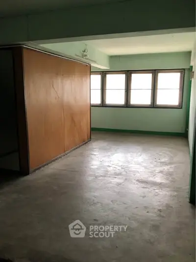 Spacious empty room with large windows and natural light, ideal for customization.