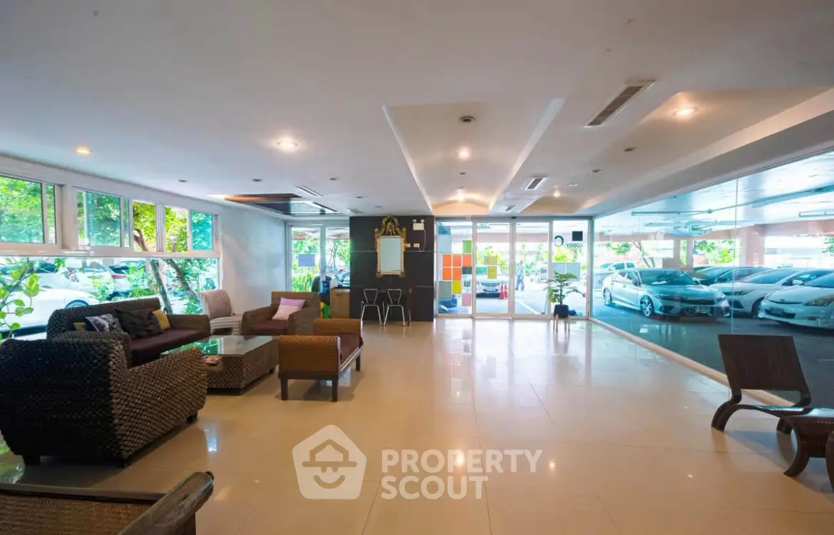 Spacious lobby with modern seating and large windows overlooking parking area.