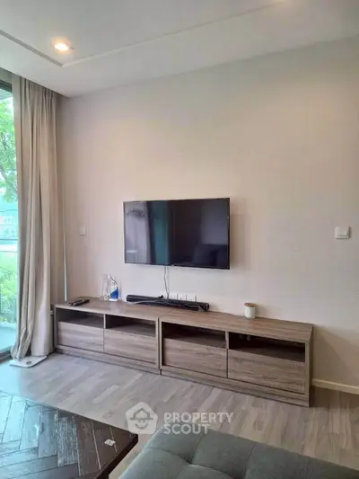 Modern living room with wall-mounted TV and stylish wooden cabinet