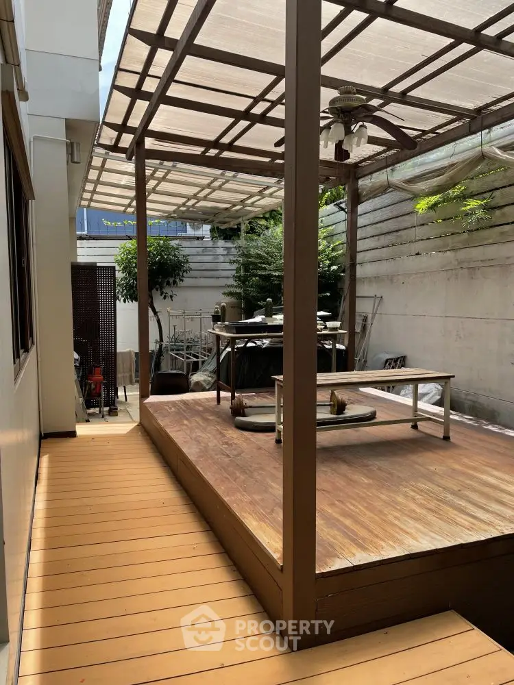 Charming outdoor patio with wooden deck and pergola, perfect for relaxation and entertaining.