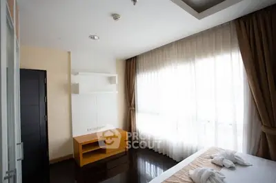 Spacious bedroom with large windows and modern furnishings