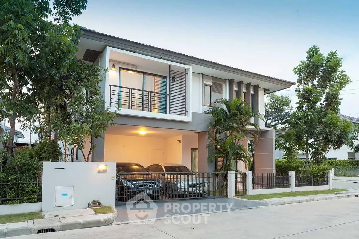 Modern two-story house with spacious driveway and lush greenery.