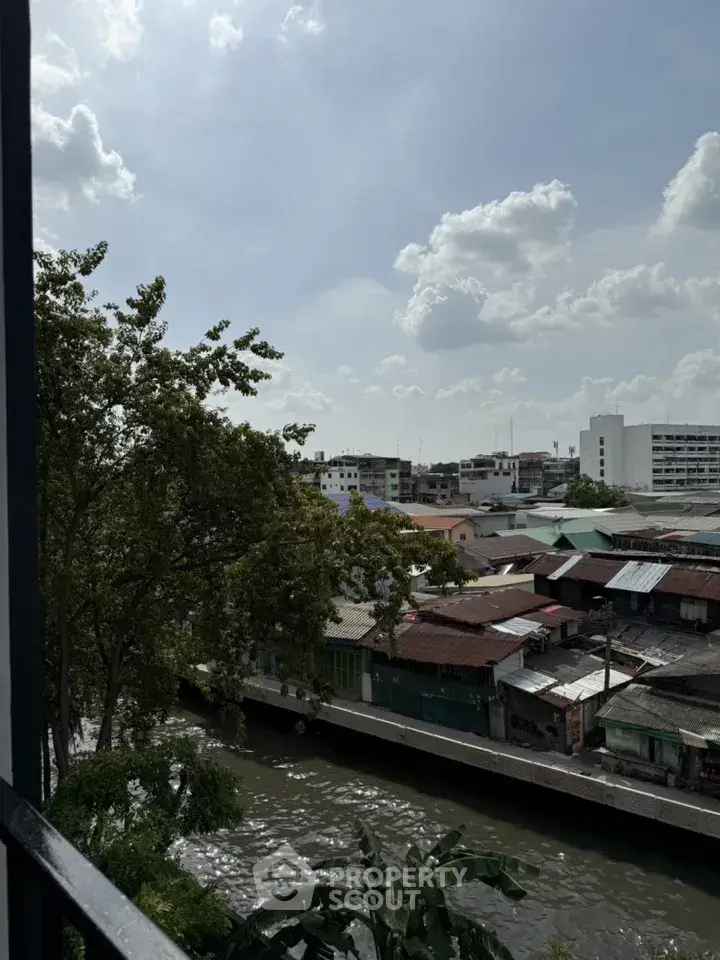 Scenic view of urban landscape with canal and residential buildings under a cloudy sky.