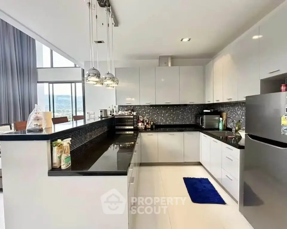 Modern kitchen with sleek design and open layout, featuring stainless steel appliances and stylish lighting.