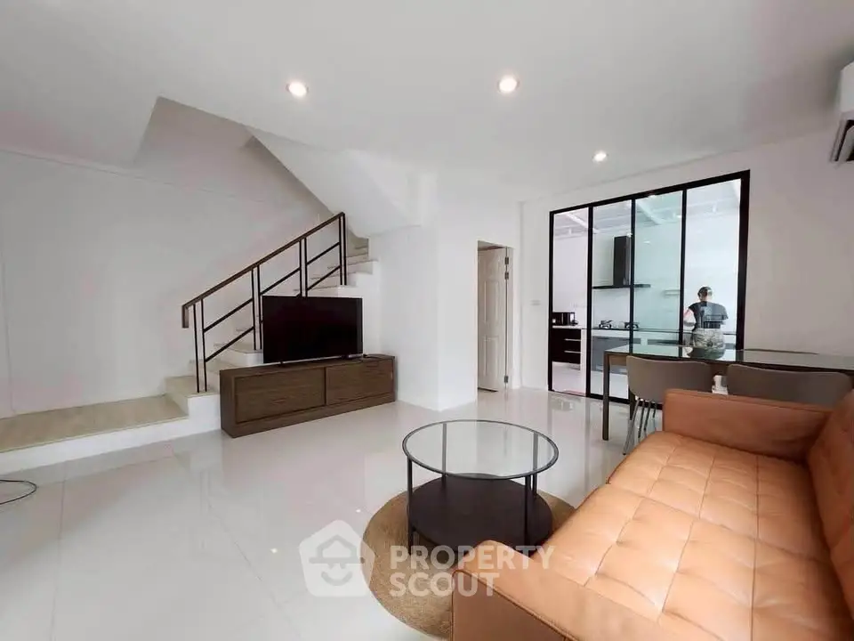 Modern living room with sleek staircase and open kitchen layout