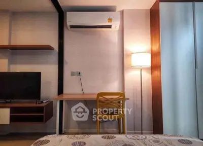 Modern bedroom with stylish desk, TV, and air conditioning unit.