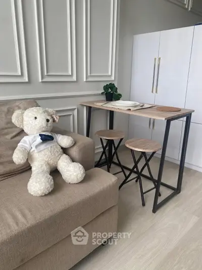 Cozy living room with stylish furniture and plush teddy bear on sofa
