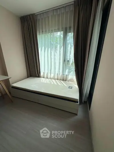 Cozy bedroom with large window and modern curtains, perfect for natural light lovers.