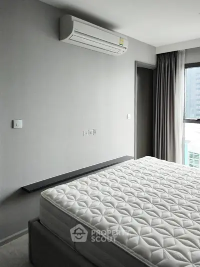 Modern bedroom with air conditioning and large window offering city view