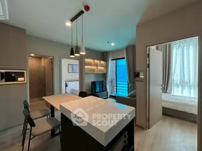 Modern open-plan living area with sleek kitchen and cozy bedroom