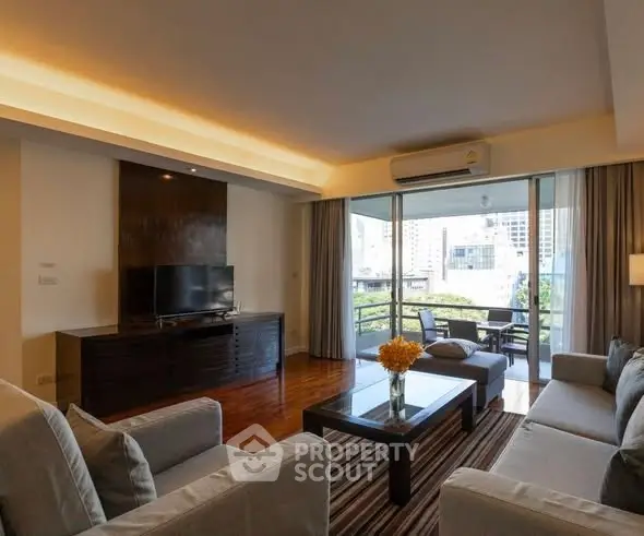 Spacious living room with modern furniture and balcony view in urban apartment.
