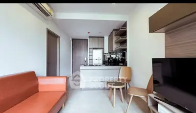 Modern living room with sleek furniture and open kitchen layout in a stylish apartment.