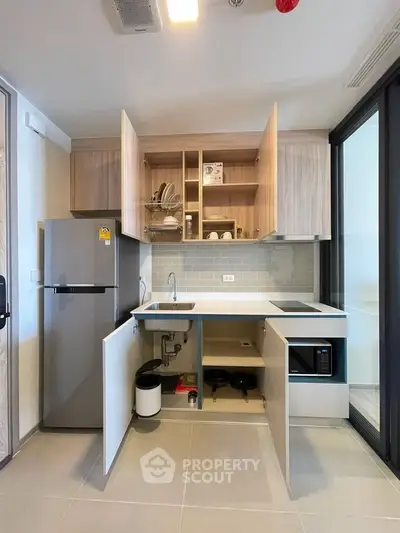 Modern kitchen with open cabinets, sleek appliances, and minimalist design in a contemporary apartment.