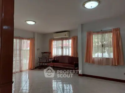 Spacious living room with natural light and classic wooden furniture