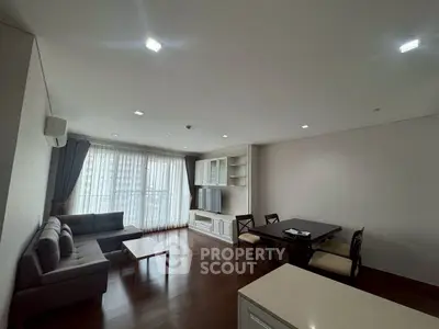 Spacious modern living room with elegant furniture and large windows offering natural light.