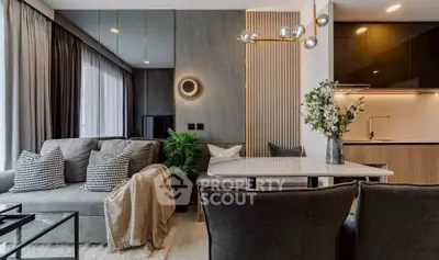 Modern living room with stylish decor and open kitchen layout, featuring cozy seating and elegant lighting.