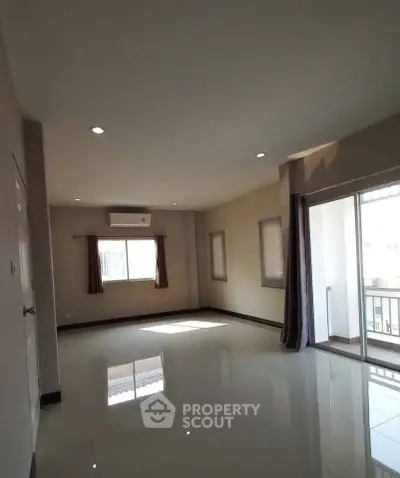 Spacious unfurnished living room with balcony access and natural light