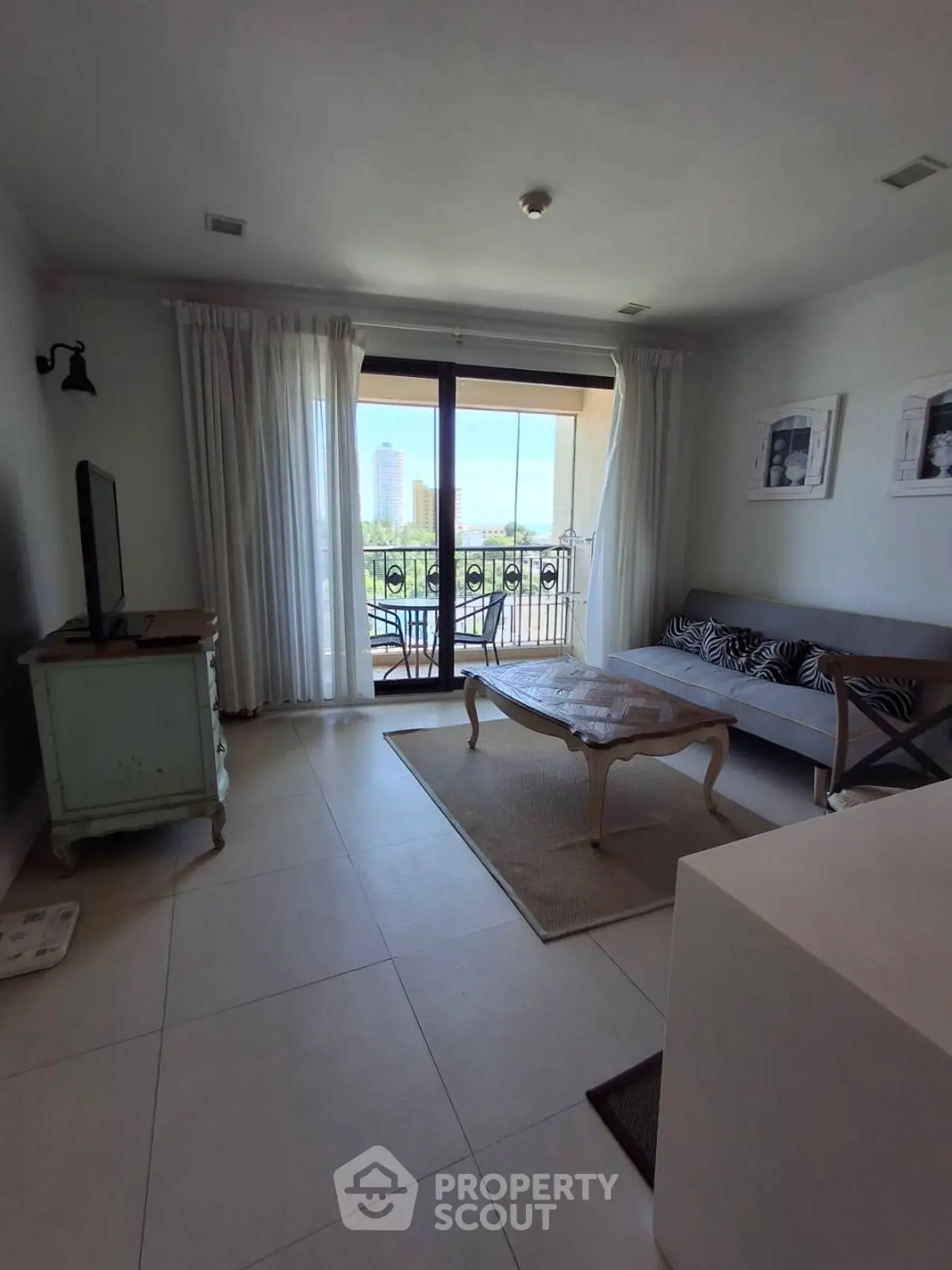 Bright living room with balcony view, stylish decor, and natural light.