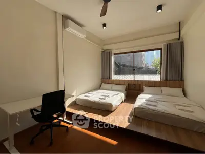 Spacious bedroom with two beds and city view, perfect for urban living.