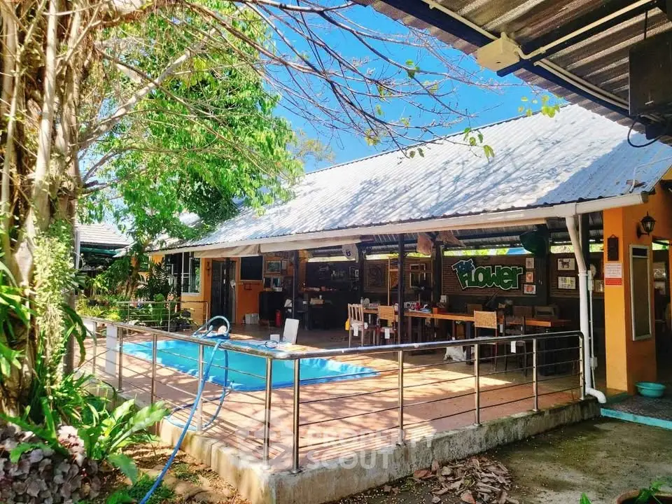 Charming outdoor pool area with rustic patio and lush greenery, perfect for relaxation and entertaining.