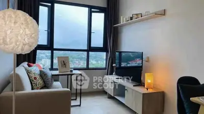 Cozy living room with large window offering stunning city views, modern decor, and comfortable seating.