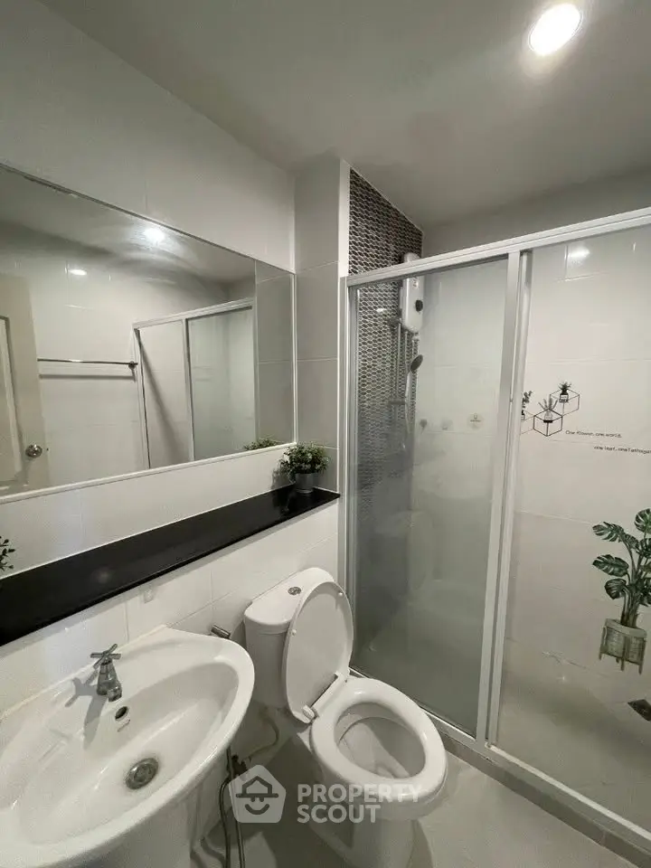 Modern bathroom with sleek fixtures and glass shower enclosure, perfect for a contemporary home.
