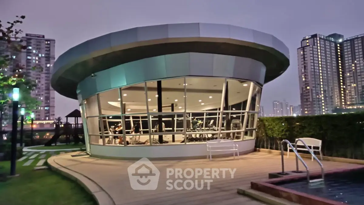 Modern gym exterior with city skyline view and outdoor pool area.