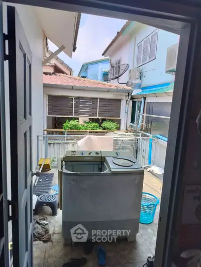 Charming outdoor laundry area with washing machine and balcony view, perfect for practical living.