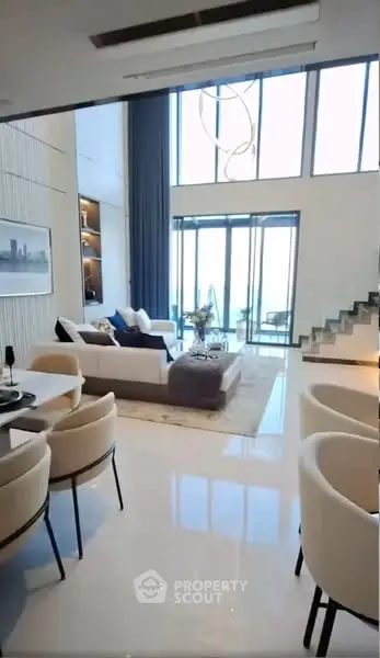 Luxurious modern living room with high ceilings and large windows offering stunning views.