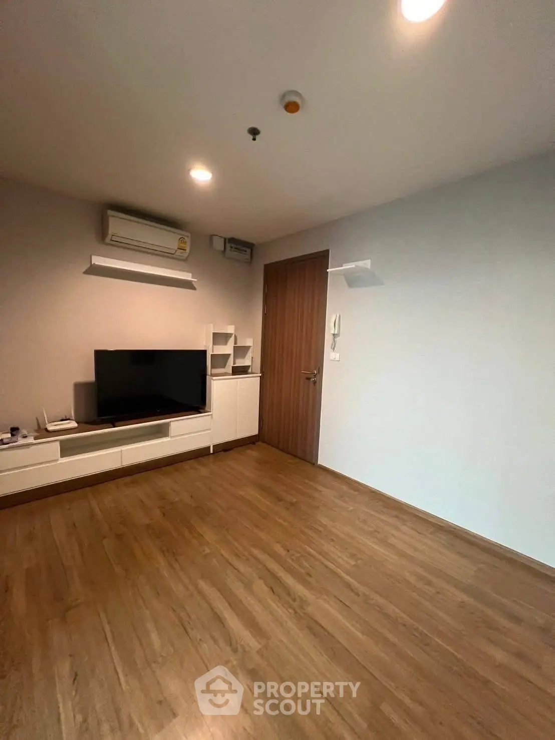 Modern living room with wooden flooring and built-in TV unit