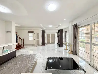 Spacious modern living room with marble flooring and large windows for natural light.