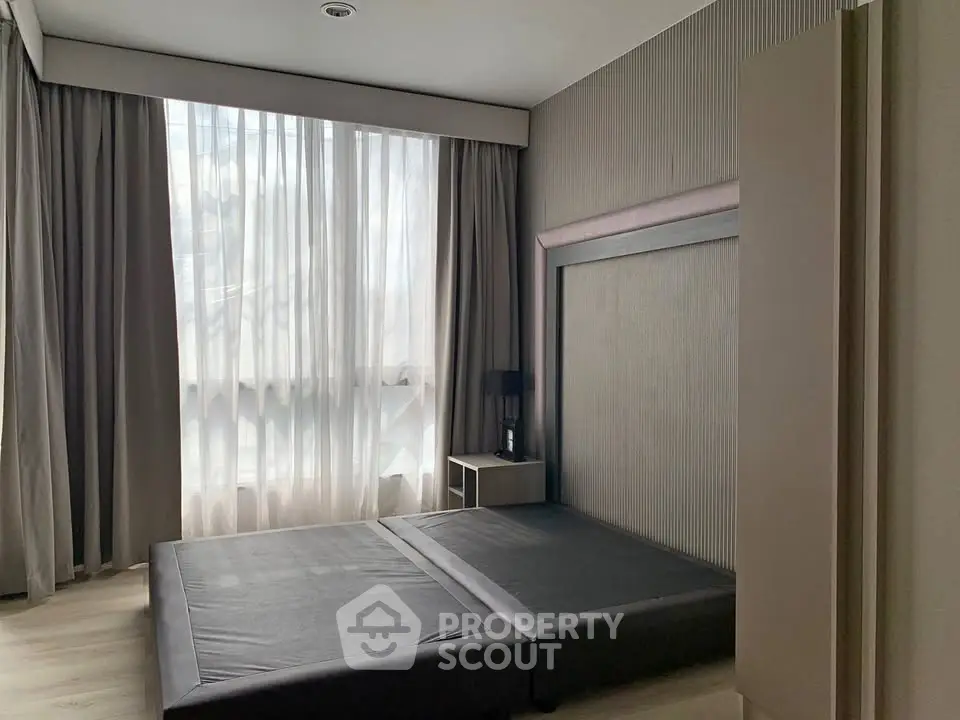 Modern minimalist bedroom with large window and neutral tones