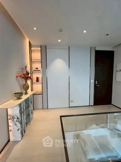 Elegant modern living room with minimalist decor and glass coffee table.