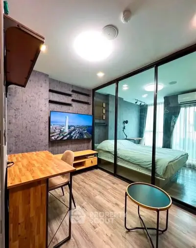 Modern studio apartment with glass partition, wooden floors, and stylish furnishings.