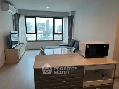 Modern living room with city view, featuring sleek furniture and a microwave on the kitchen counter.