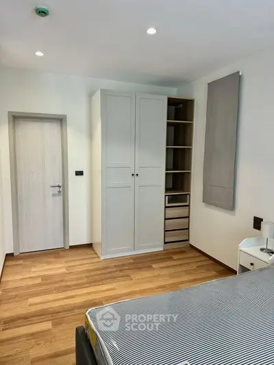 Modern bedroom with wooden flooring and sleek wardrobe design