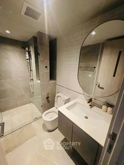 Modern bathroom with sleek design, featuring a glass shower and stylish vanity.