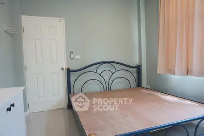 Spacious bedroom with large windows, natural light, and a stylish metal bed frame, perfect for restful nights in a serene setting.